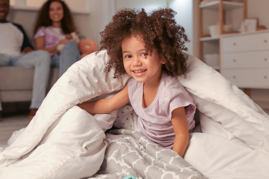 toddler smiling wrapped in comforter